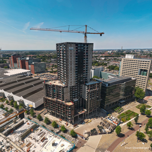 Grote toren met torenkraan en een blauwe lucht